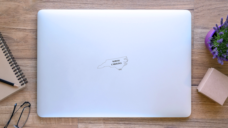 A North Carolina State Outline Lettering Sticker on a Laptop (New) example