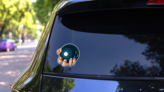 A Strong Hand Holding A Bowling Ball Sticker on a Rear Car Window (New) example