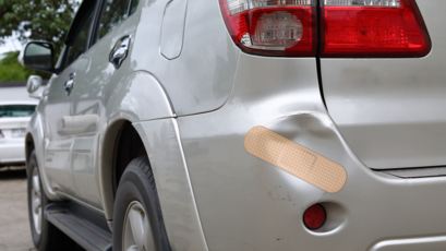 Custom Band Aid Sticker on a Bumper with a Dent in It