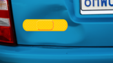 Bright Yellow Band Aid Bandage Sticker on a Dented Car example