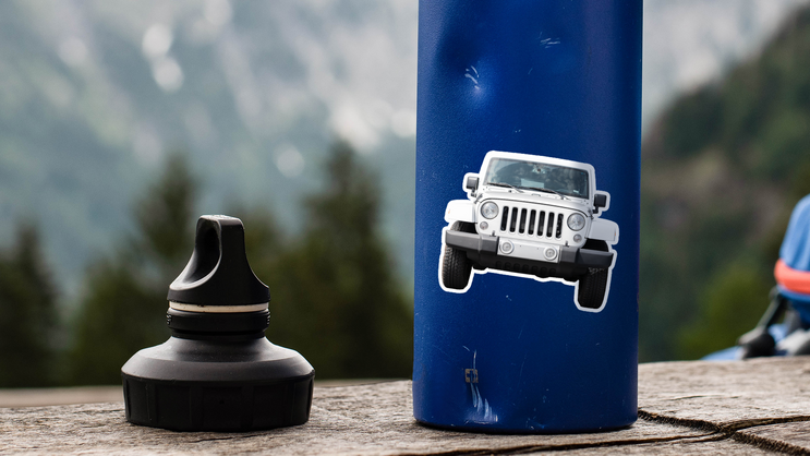 Photo sticker of a jeep on a dented water bottle