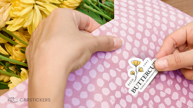 Someone applying a die cut sticker to a flower bouquet