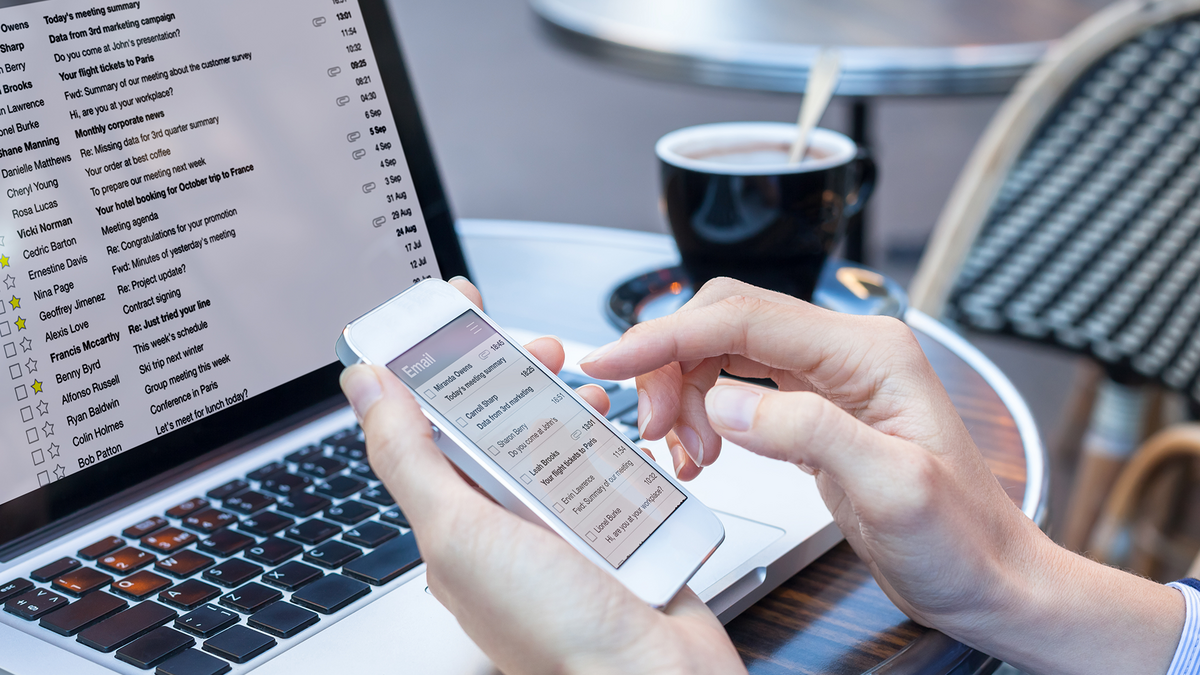 Scrolling through email on phone while email is up on the laptop