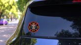 Fire Department Cross Volunteer Black Helmet Sticker on a Rear Car Window (New) example