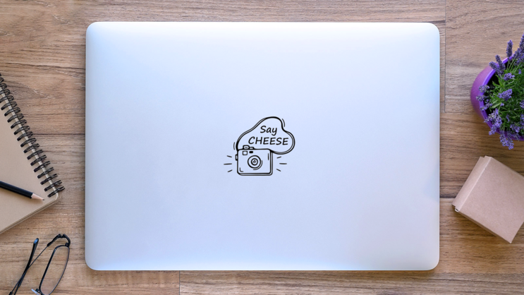 Hand Drawn Сute Camera Say Cheese Sticker on a Laptop (New) example