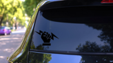 Hand Holding Lightning Bolt Sticker on a Rear Car Window (New) example