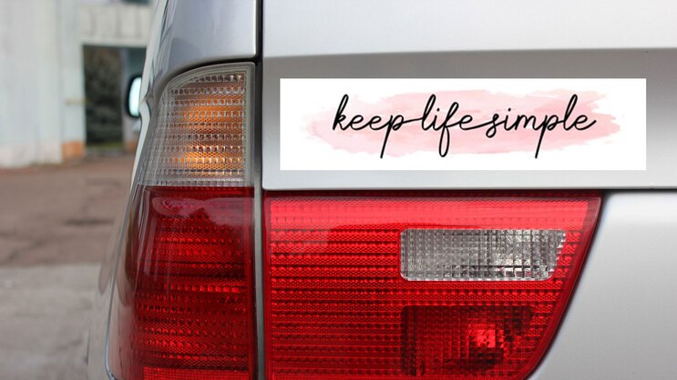 Keep Life Simple Bumper Sticker on a Gold Car Rear Bumper example