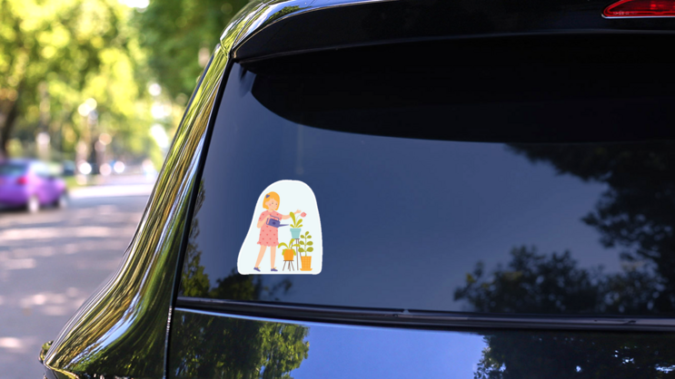 Little Girl Is Watering Indoor Plants Sticker on a Rear Car Window (New) example