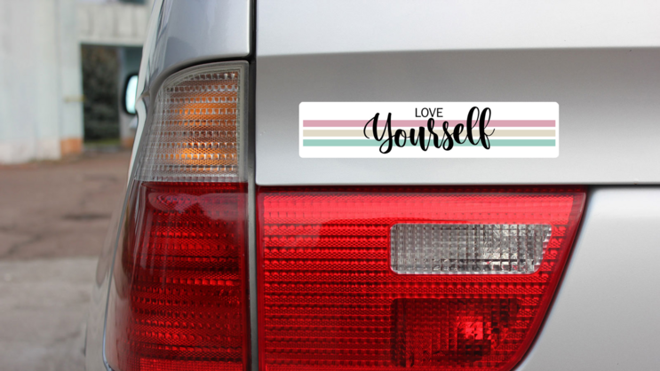 Love Yourself Bumper Sticker on a Gold Car Rear Bumper example