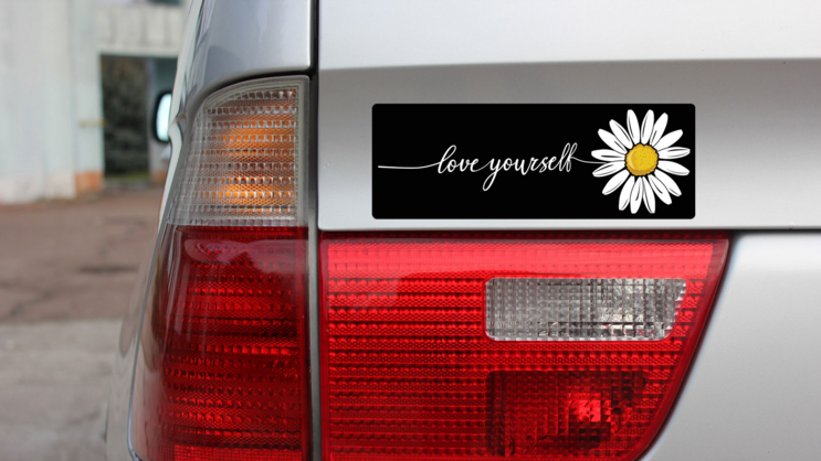 Love Yourself Daisy Bumper Sticker on a Gold Car Rear Bumper example