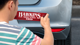 Man applying a bumper sticker to his car