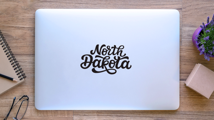 North Dakota Calligraphy Sticker on a Laptop (New) example