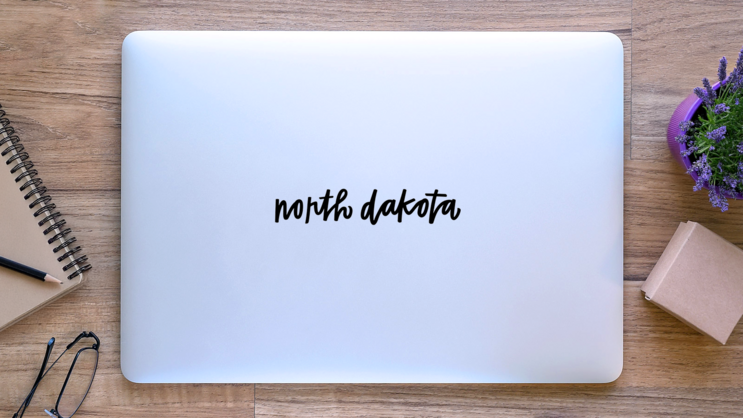 North Dakota Hand Lettering Sticker on a Laptop (New) example