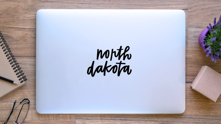 North Dakota Hand Script Sticker on a Laptop (New) example