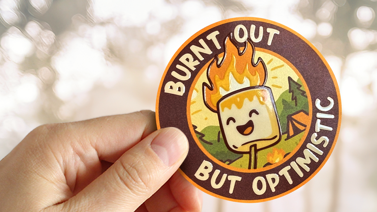 A close up shot of a person holding an embossed sticker catching the light.