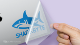 A shark transfer decal being applied to a laptop.