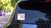 Snail With Rainbow Shell Smile Sticker on a Rear Car Window (New) example