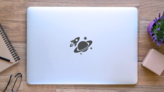 Spaceship Orbiting Saturn Sticker on a Laptop (New) example
