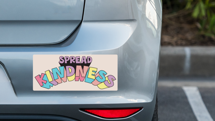 Spread Kindness Bumper Sticker on a Grey Car Bumper example