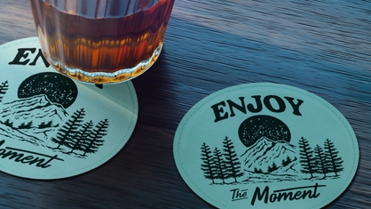 Teal coaster with Enjoy The Moment engraved into it