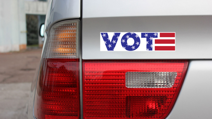 VOTE USA Themed Bumper Sticker on a Gold Car Rear Bumper example