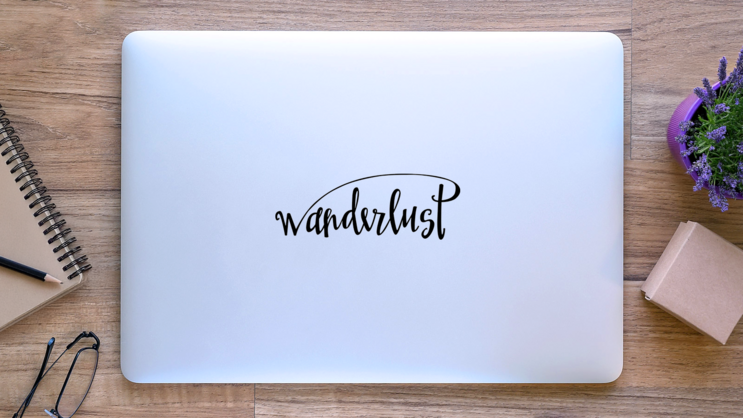 Wanderlust Script Sticker on a Laptop (New) example