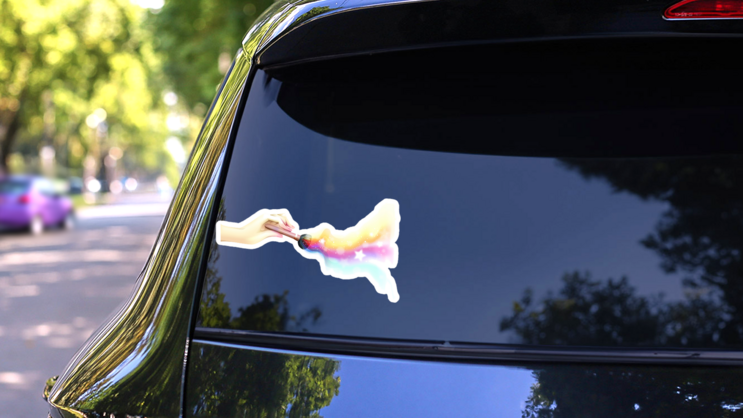 Whimsical Hand Using A Makeup Brush Sticker on a Rear Car Window (New) example