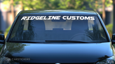 A custom windshield decal for a car club across the top of vehicle.