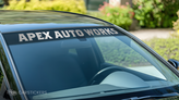 A metallic windshield decal advertising an auto business.