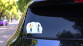 Woman With Bow Aiming Arrow At Apple On Mans Head Sticker on a Rear Car Window (New) example